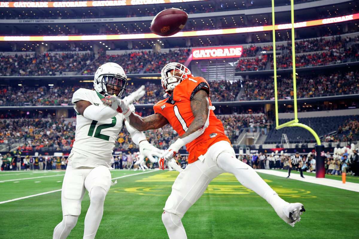 Baylor cornerback Kalon Barnes (12) breaks up a pass in the end zone intended for Oklahoma State wide receiver Tay Martin (1) during an NCAA college football game for the Big 12 Conference championship in Arlington, Texas, Saturday, Dec. 4, 2021. (Ian Maule/Tulsa World via AP)