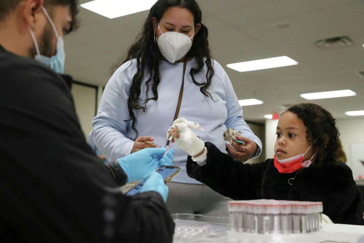 Stella Santini, 5, puts a swab into a test tube as her mother, Estrella, looks on during a testing day at Pre-K 4 SA on Monday, Jan. 3, 2022. Staff, students and parents at Pre-K 4 SA were provided COVID testing through Community Labs on Monday. Locally based Community Labs is in talks with the San Antonio Metropolitan Health District to provide additional COVID-19 testing.