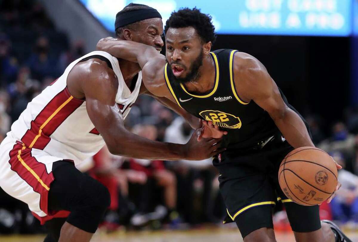 Golden State Warriors' Andrew Wiggins commits an offensive foul while driving to the basket against Miami Heat's Jimmy Butler in 2nd quarter during NBA game at Chase Center in San Francisco, Calif., on Monday, January 3, 2022.