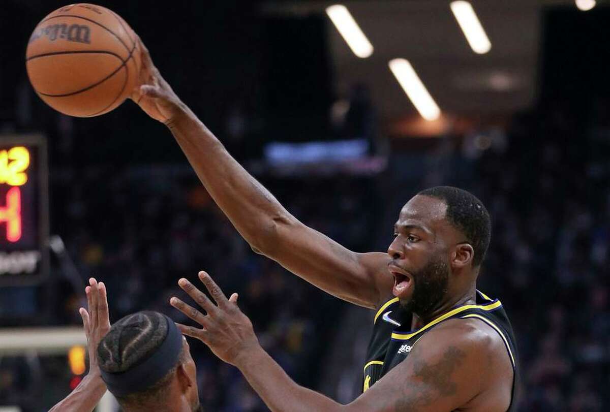 Golden State Warriors' Draymond Green passes over Miami Heat's Jimmy Butler in 1st quarter during NBA game at Chase Center in San Francisco, Calif., on Monday, January 3, 2022.