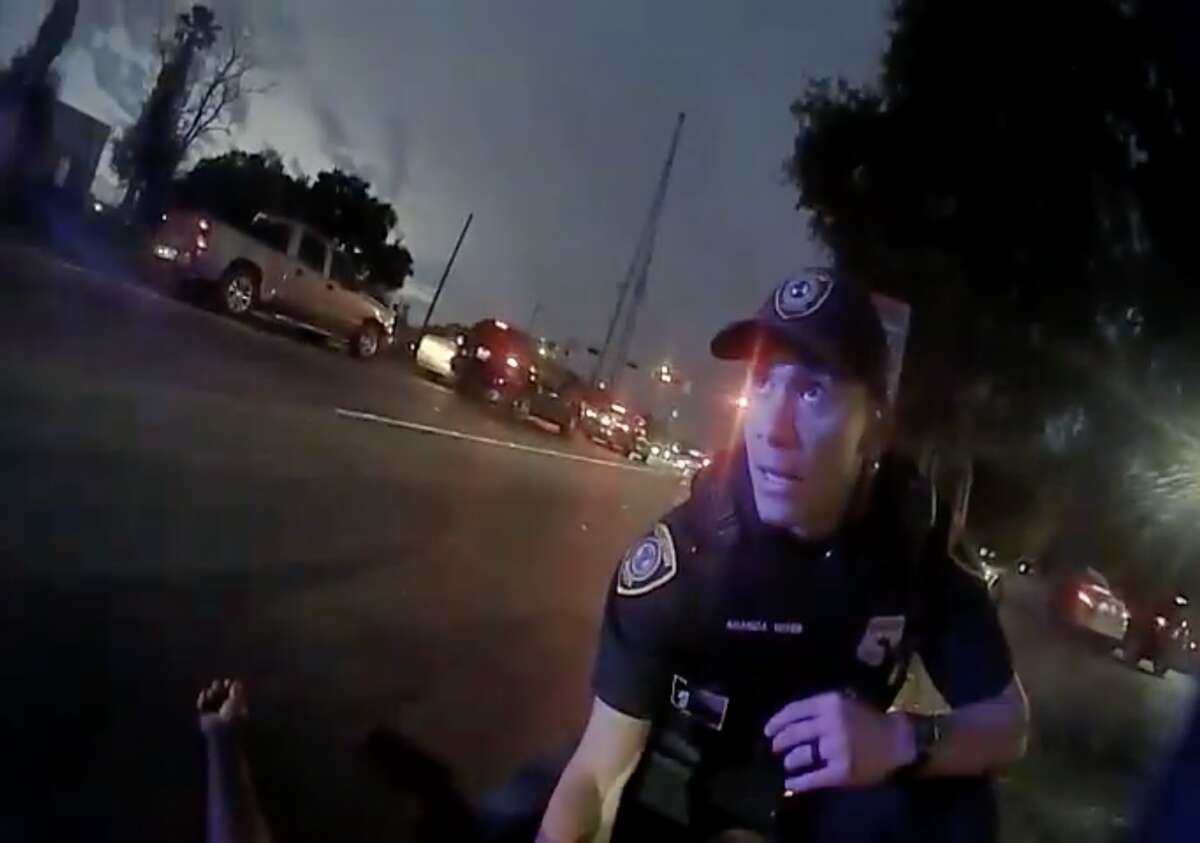 In this still from police body-camera footage, Houston police officer Anthony Aranda crouches over Michael Wayne Jackson, 62, after his partner ofc. Orlando Hernandez drove their patrol cruiser onto the sidewalk at 4100 Reed Road, killing Jackson, on Saturday, Dec. 4, 2021. 