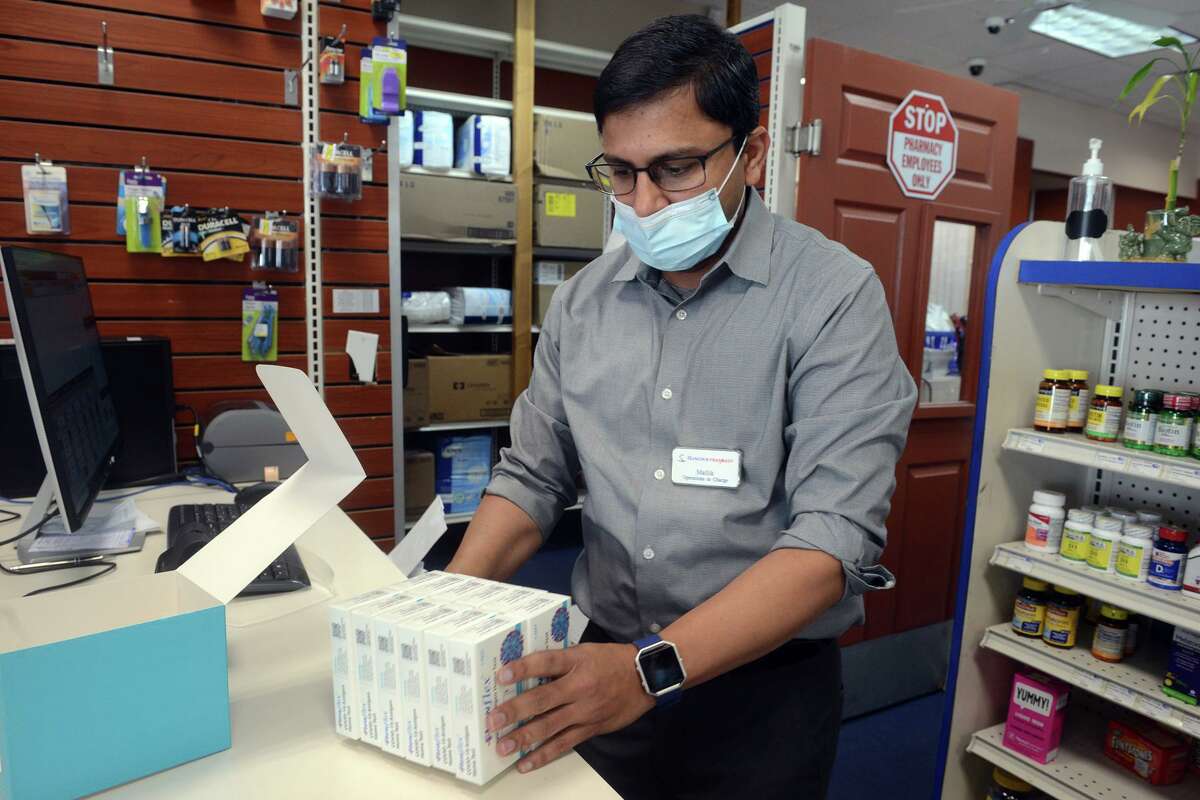 Store manager Mallik Appalaneni unboxes COVIC-19 home test kits at one of the Hancock Pharmacy locations in Bridgeport, Conn. Jan. 4, 2022.