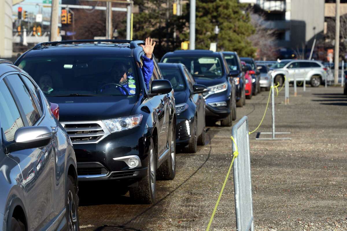 Cars line up for a drive-thru COVID-19 home test kits distribution in a parking lot near Webster Bank Arena and Hartford Healthcare Amphitheater, in Bridgeport, Conn. Jan. 4, 2022.