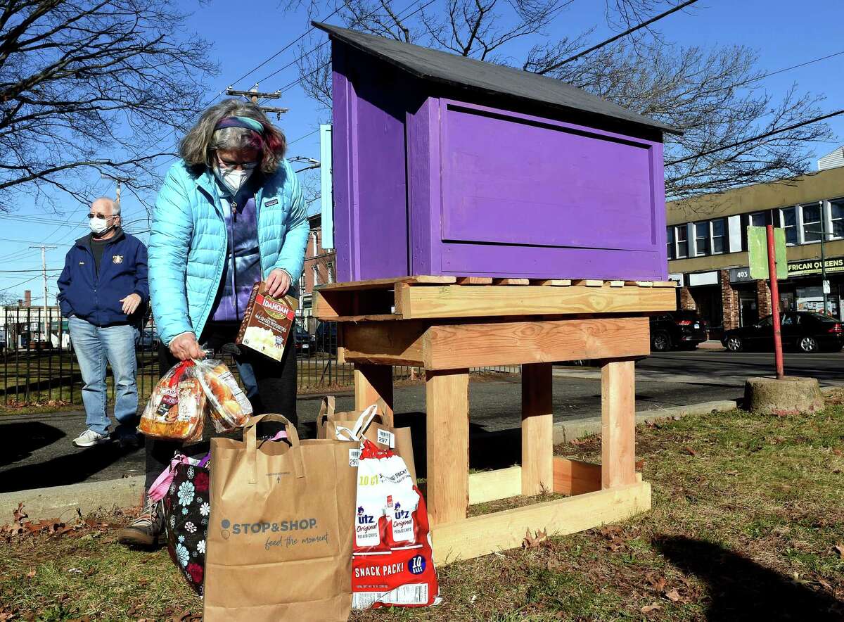 Susan Brown, director and founder of Purple Pantry Boxes, stocks the newest Purple Pantry Box with food in front of the First Congregational Church on Campbell Avenue in West Haven Jan. 4, 2022.