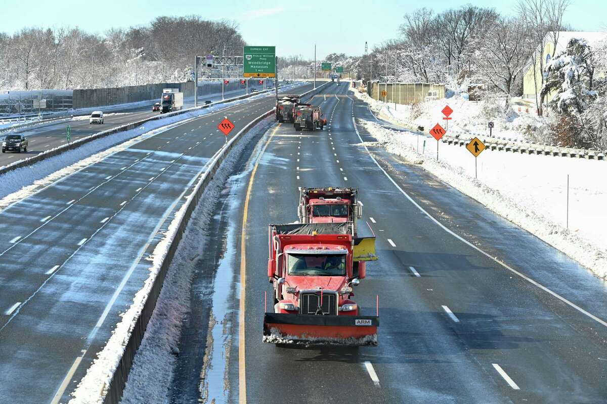 Snowplow vehicles head north along the closed southbound lanes of I-95 in Woodbridge on Tuesday.