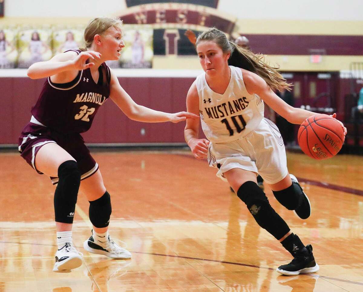 Magnolia West's Faith Matocha (10) drives past Magnolia's Emma Rowan (32) during the first quarter of a high school basketball game at Magnolia West High School, Tuesday, Jan. 4, 2022, in Magnolia.