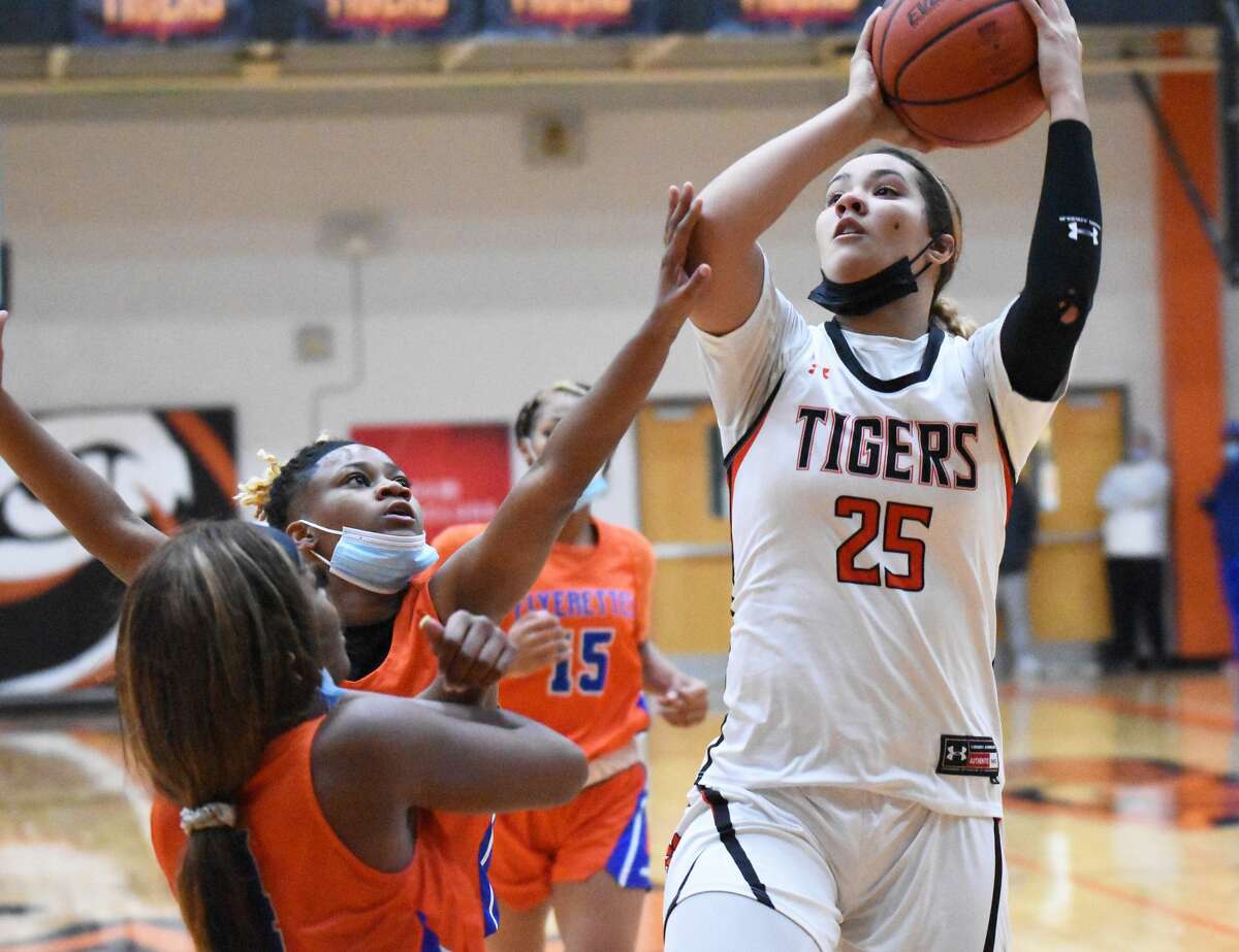 Edwardsville's Sydney Harris is fouled going up for a shot during the first half against East St. Louis on Tuesday inside Lucco-Jackson Gymnasium in Edwardsville.