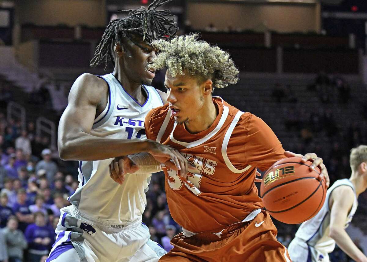 MANHATTAN, KS - JANUARY 04: Tre Mitchell #33 of the Texas Longhorns drives against Carlton Linguard Jr. #12 of the Kansas State Wildcats during the first half at Bramlage Coliseum on January 4, 2022 in Manhattan, Kansas.