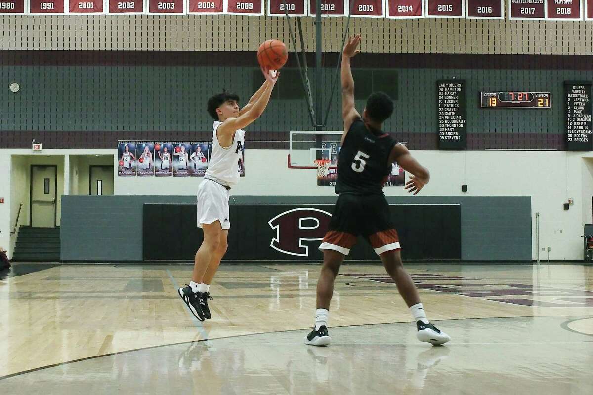 Pearland’s Josh Vitela (1) puts up a shot over Alvin’s Kendrick Bailey (5) Tuesday at Pearland High School.