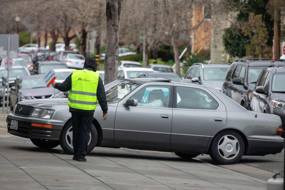 People in cars wait in line to get a COVID-19 test by car at Kaiser Permanente Hospital in Oakland, Calif., Jan. 4, 2022. The line stretched over three blocks, causing people to wait more than an hour to receive an RT-PCR test COVID.