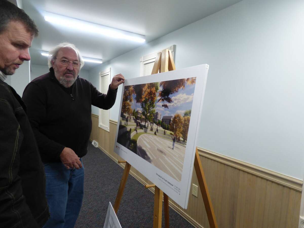 Manistee County commissioner Eric Gustad (left) and Filer DDA secretary Al Frye consider artistic renderings of a potential mixed-use development being planned in Filer Township.