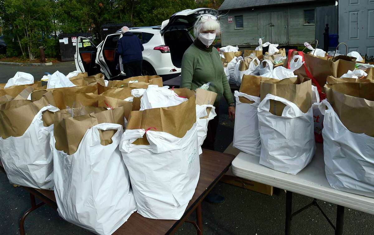Volunteers at Person-to-Person prepare bags of food for pickup on Friday, November 19, 2021, at their facility in Darien, Conn. The Giving Fund helps to support clients at Person-to-Person.