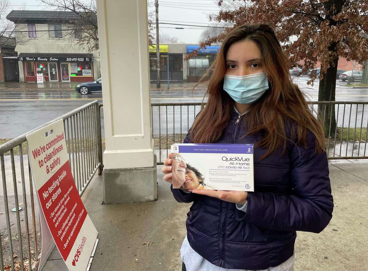 New Haven resident Patricia Araque stands outside CVS on Whalley Avenue after buying an at-home COVID-19 test, which has been hard to find.