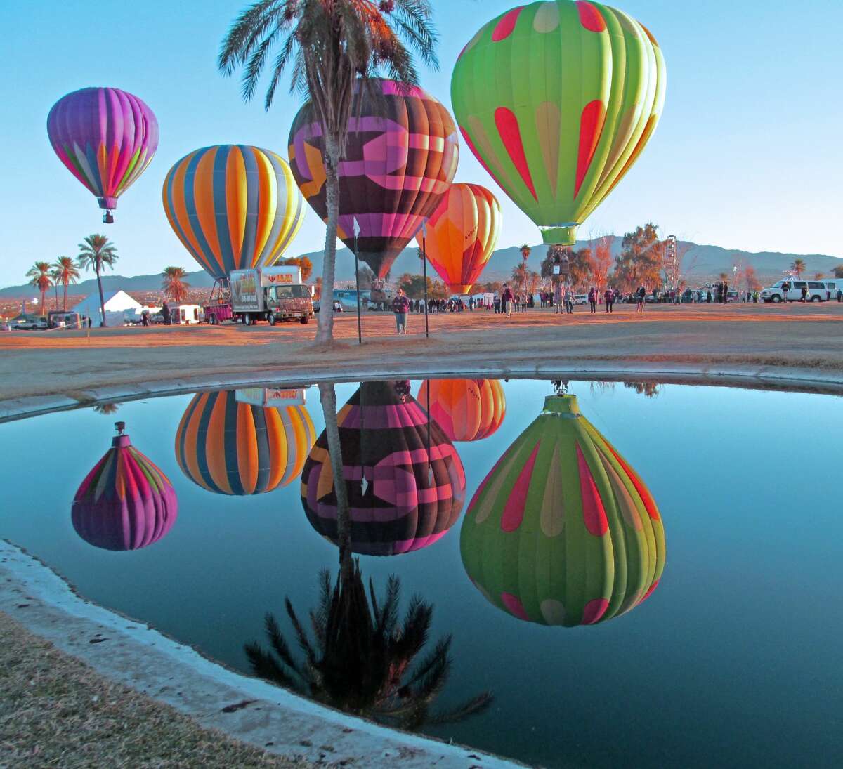 Hot air balloons reflected in pond at Lake Havasu Balloon Festival.