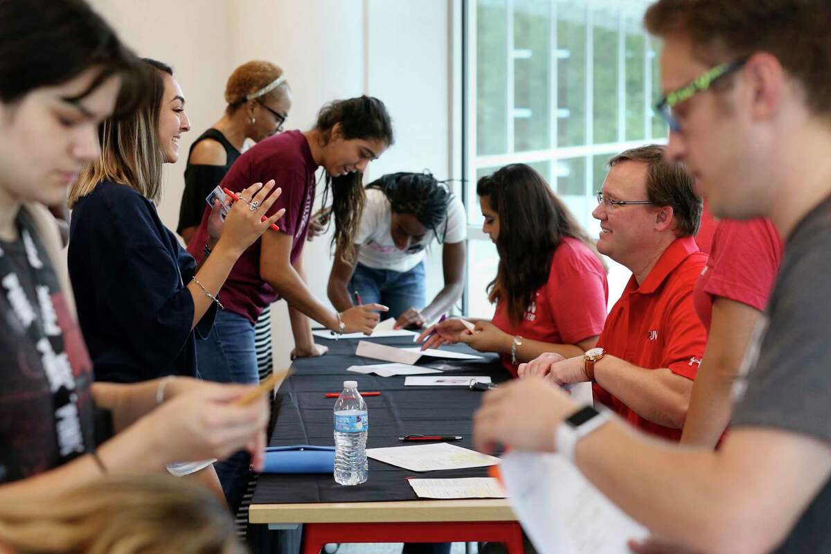 University of the Incarnate Word President Thomas Evans, right in red, checks in incoming freshman Alexis V. Gutierrez, 18, of McAllen, at the new Student Center, Thursday, August 24, 2017. Evans took over the position from Louis Agnese who led the university for three decades but left under a swirl of controversy.