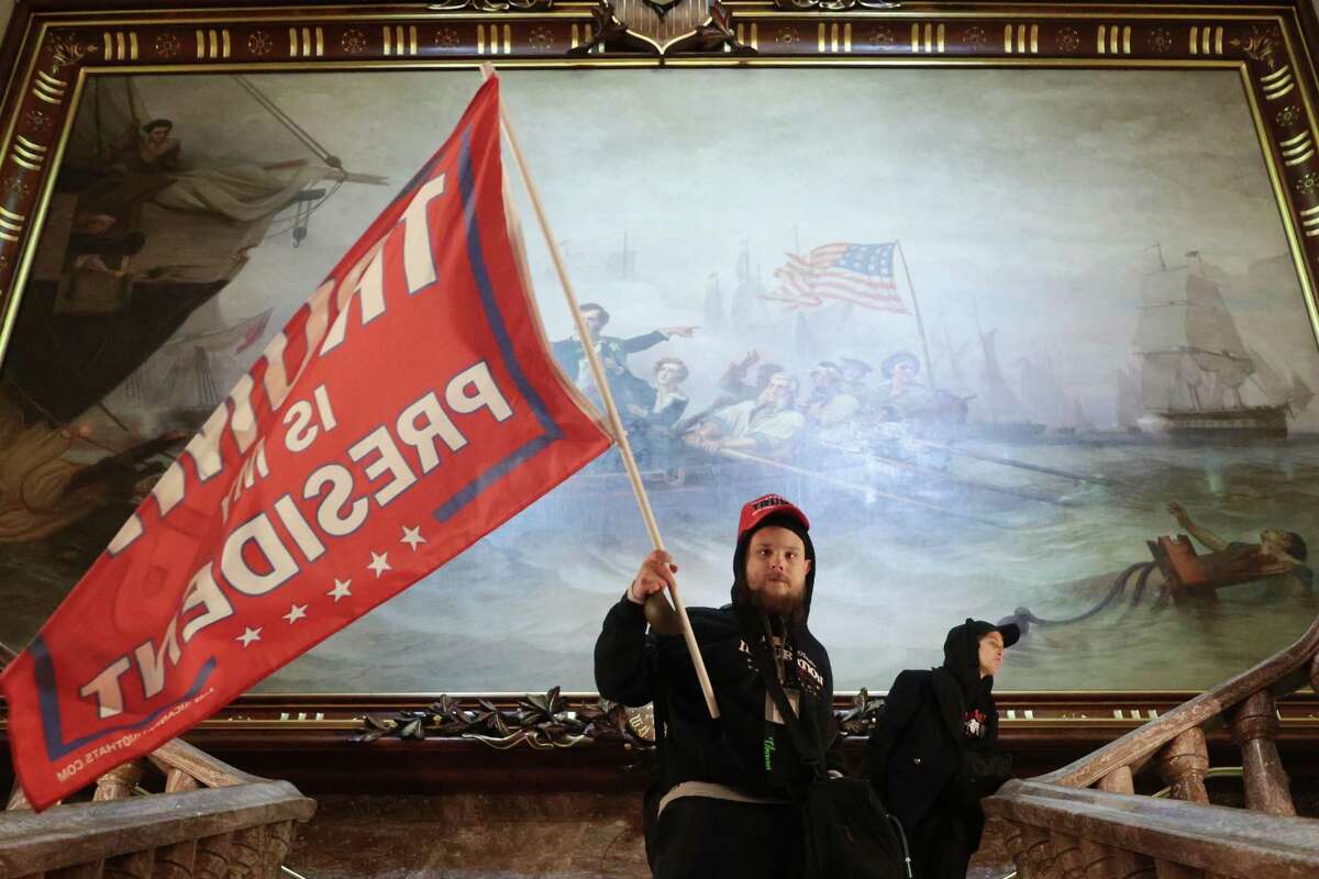 A protester holds a Trump flag inside the U.S. Capitol near the Senate chamber on Jan. 6, 2021.
