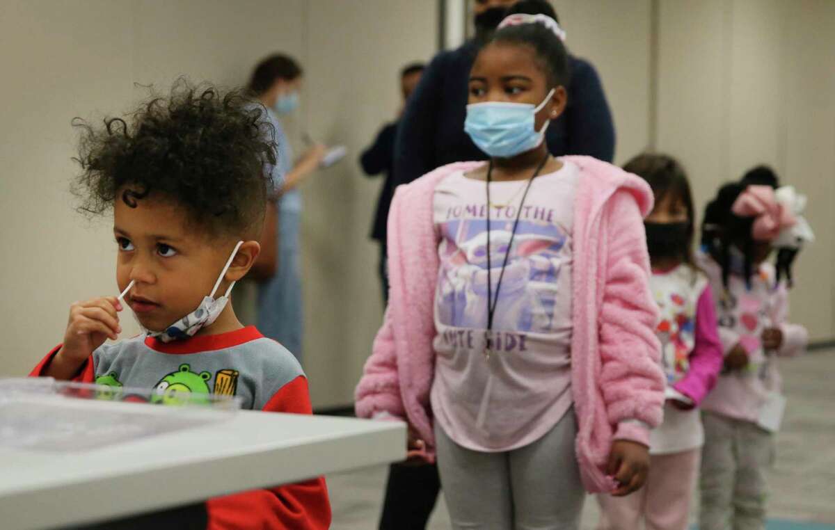 Five-year-old Calvin (no last name provided) swabs his nose as other children wait in line at Pre-K 4 SA on Monday, Jan. 3, 2022. Most districts in Bexar County prepare to return to school as scheduled this month despite the COVID omicron-variant surge. Staff, students and parents at Pre-K 4 SA were provided COVID testing thru Community Labs on Monday. Over 300 tests were expected to be administered with results back in about 24 hours.