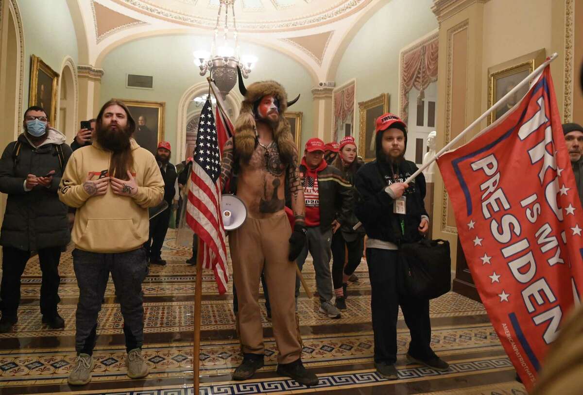 Supporters of US President Donald Trump, including member of the QAnon conspiracy group Jake Angeli, aka Yellowstone Wolf (C), enter the US Capitol on January 6, 2021, in Washington, DC.