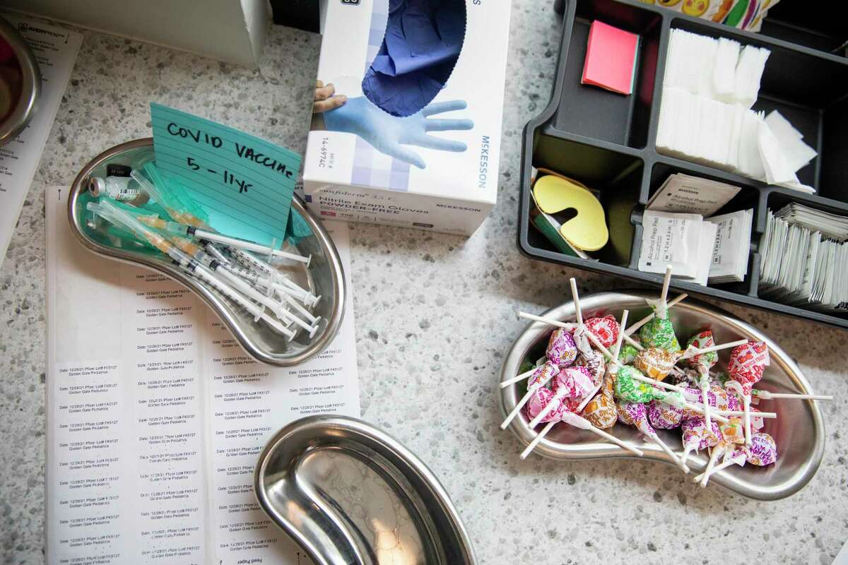 A tray of Pfizer COVID-19 vaccine lies next to a tray of lollipops in an examination room at Golden Gate Pediatrics.