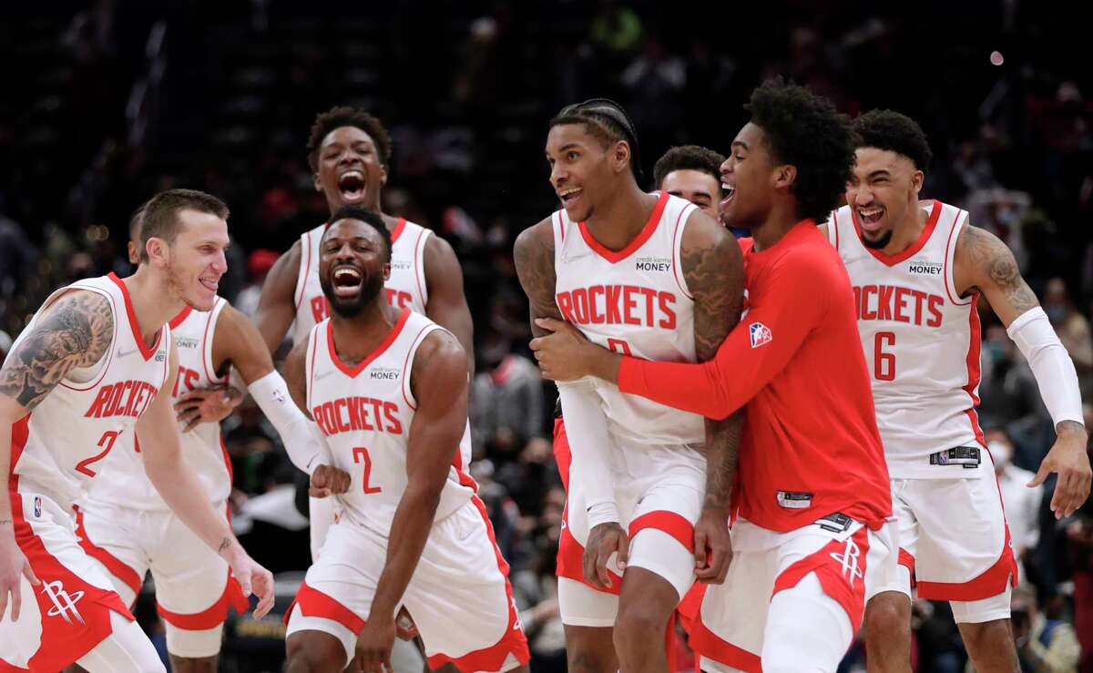 Houston Rockets' Kevin Porter Jr., front second from right in front, celebrates with his teammates after making the game-winning 3-point shot in the team's NBA basketball game against the Washington Wizards, Wednesday, Jan. 5, 2022, in Washington. (AP Photo/Luis M. Alvarez)