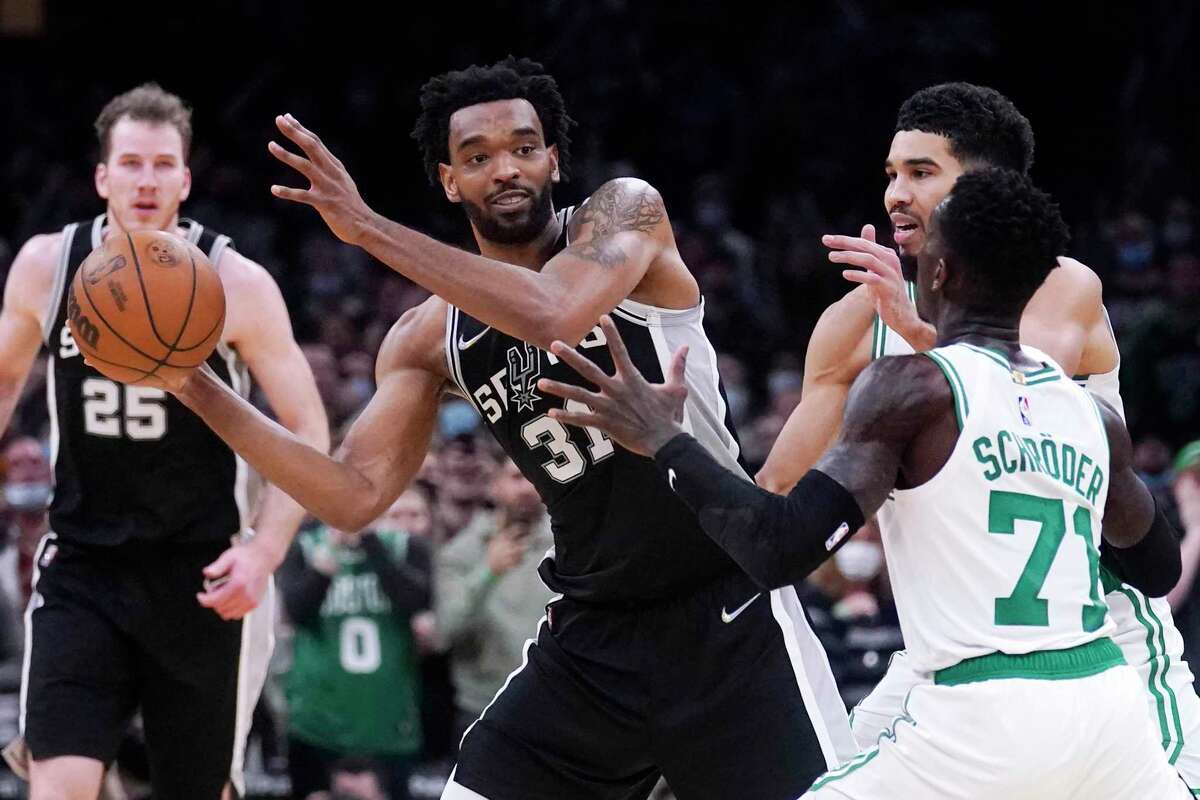 San Antonio Spurs forward Keita Bates-Diop (31) looks to pass while pressured by Boston Celtics guard Dennis Schroder (71) during the second half of an NBA basketball game, Wednesday, Jan. 5, 2022, in Boston.