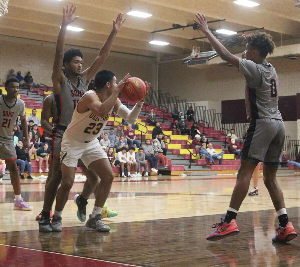 Deer Park's Victor Guerrero, hemmed in from behind, is about to pass the ball back outside to Colton Pettit, who would knock down his fifth 3-point bucket of the night in the 58-39 surprise win.