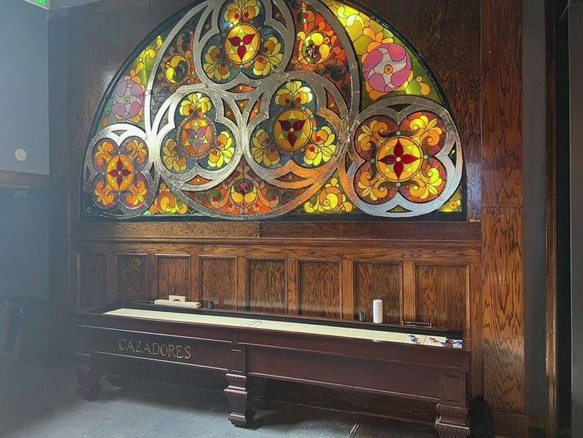 A stained-glass wall inside Lost Marbles is original to the building, but the new owners added LED lights behind it.