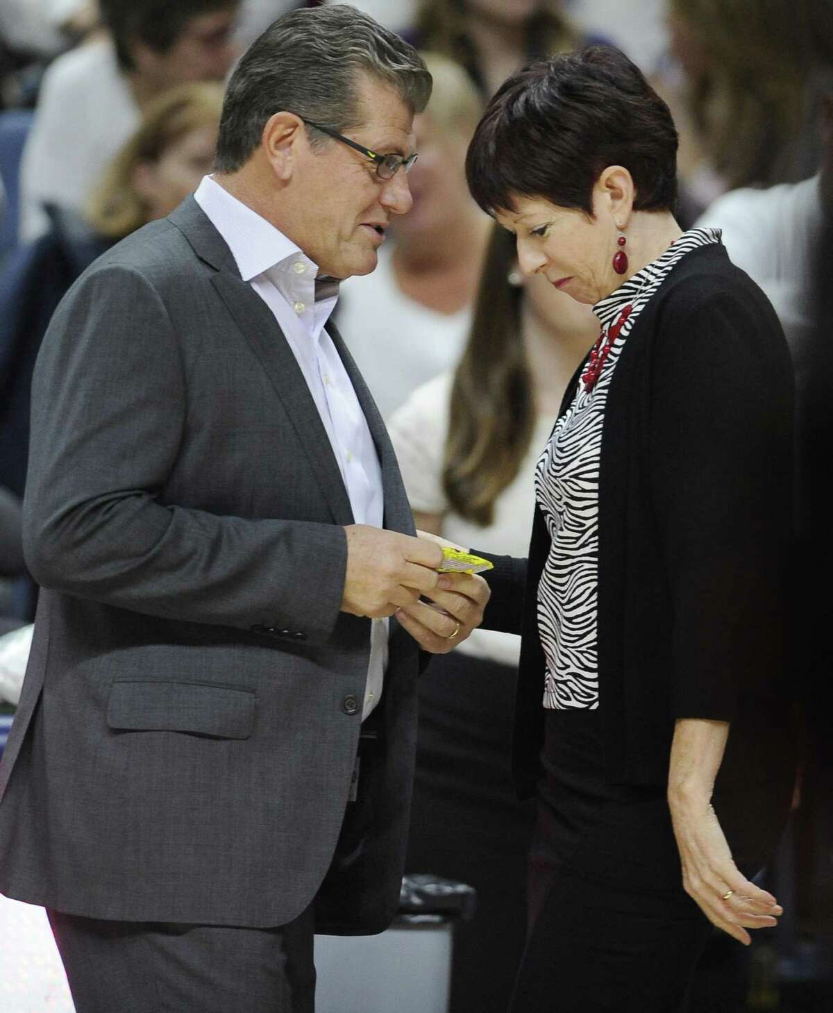 UConn coach Geno Auriemma, left, hands Notre Dame coach Muffet McGraw a gift for her 60th birthday before a 2015 game. The long-running beef between Auriemma and McGraw reared its head again this past week.
