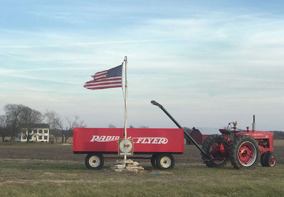 A tractor pulls a homemade not-so-little red wagon.