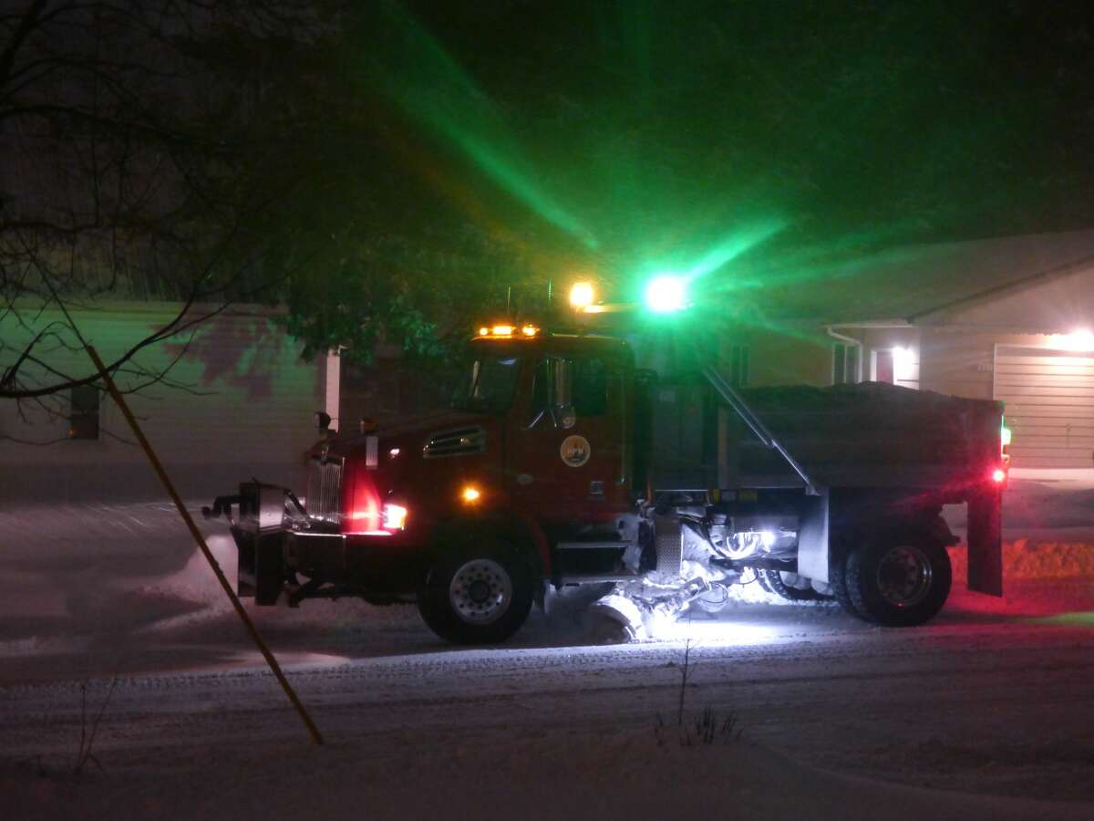 Aa Department of Public Works vehicle plows snow early Thursday morning in Manistee.