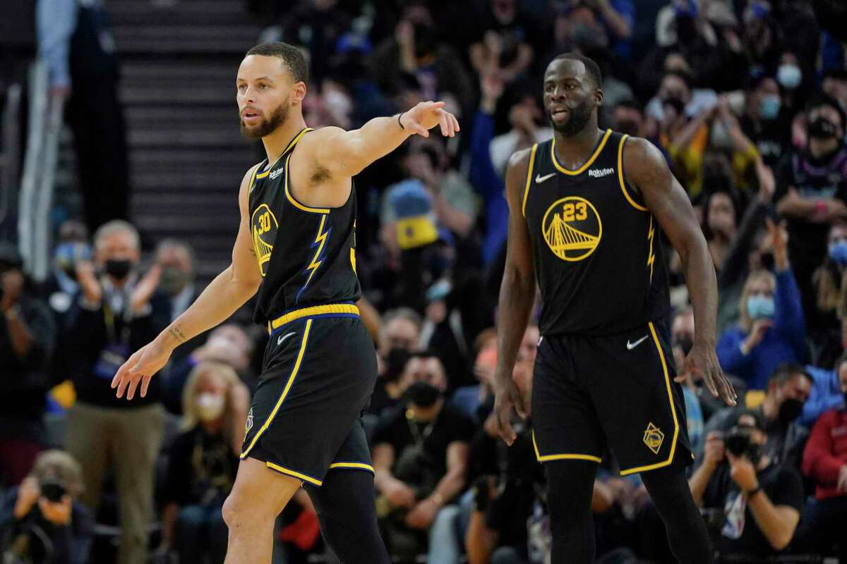 Golden State Warriors guard Stephen Curry (30) and forward Draymond Green (23) during an NBA basketball game against the Miami Heat in San Francisco, Monday, Jan. 3, 2022. (AP Photo/Jeff Chiu)