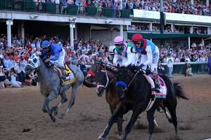 Medina Spirit, ridden by John Velazquez, far right, races towards the finish line during the 147th Kentucky Derby at Churchill Downs in Louisville, Ky., on Saturday, May 1, 2021. Medina Spirit, whose victory in the Kentucky Derby had been called into question by a failed post-race drug test, died on Monday, Dec. 6, 2021 after suffering an apparent heart attack at the Santa Anita Park racetrack in Southern California, said Dr. Jeff Blea, the equine medical director for the California Horse Racing Board. (Christian Hansen/The New York Times)