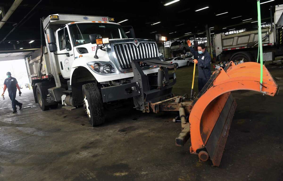 Juracy Silva guides a truck to hook up a snowplow at the New Haven Department of Public Works Jan. 6, 2022, in preparation for the upcoming snowstorm.