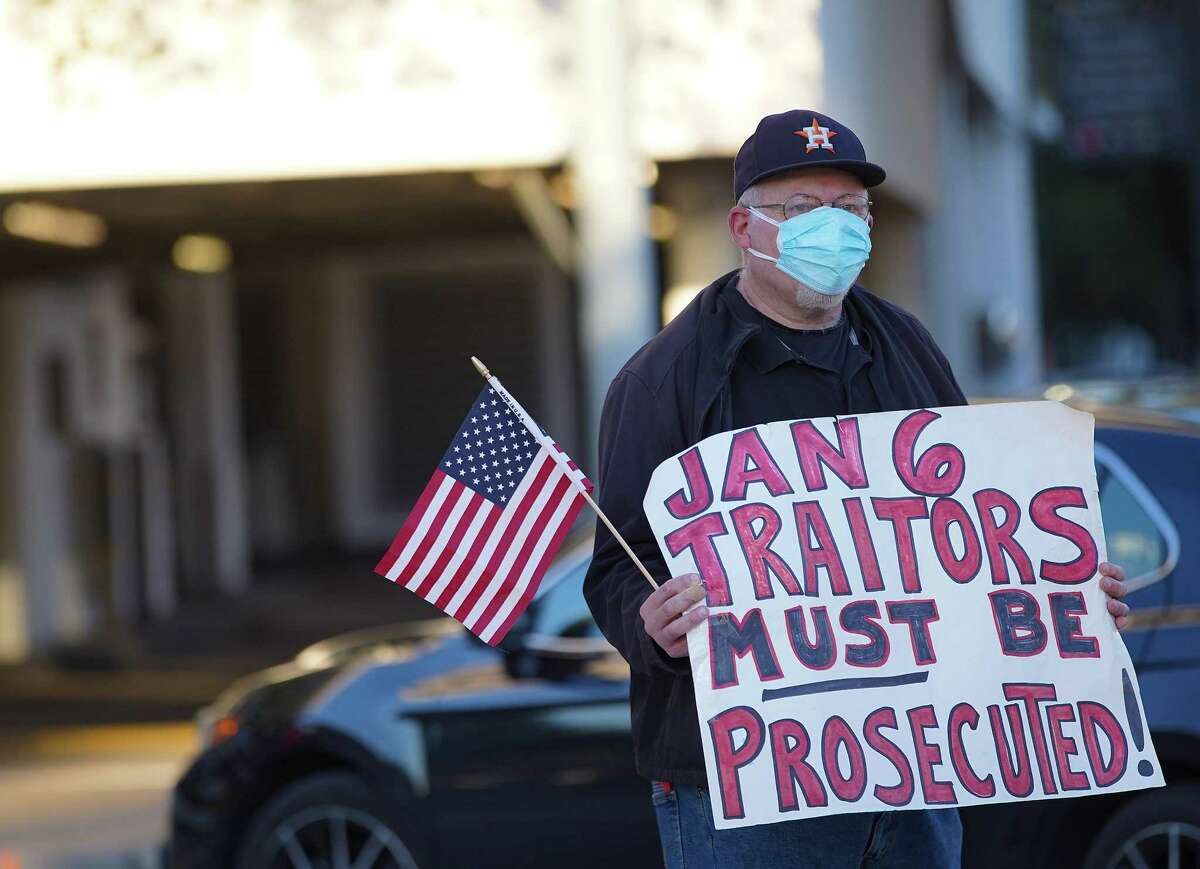 Neil Aquino of Houston holds a sign during a vigil and protest in response to last year’s Jan 6 insurrection last year at the Mickey Leland Federal Building in Houston on Thursday, Jan. 6, 2022.