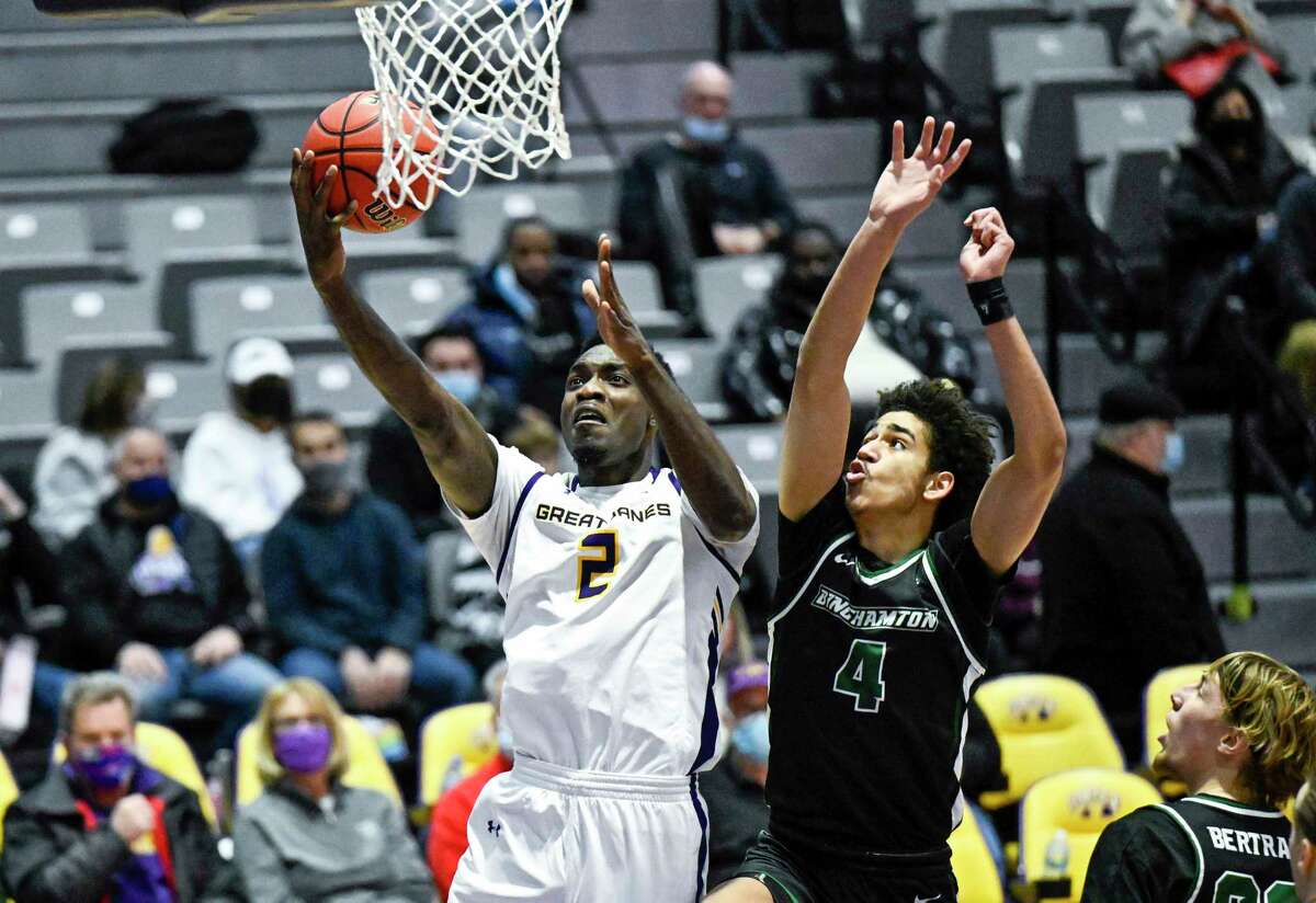 Albany forward Dre Perry (2) scores in front of Binghamton guard Kellen Amos (4) during an NCAA basketball game Thursday, Jan. 6, 2022, in Albany, N.Y.