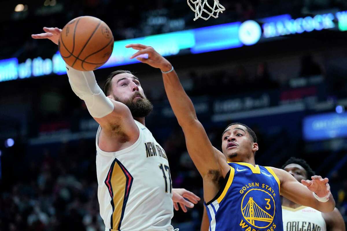 New Orleans Pelicans center Jonas Valanciunas (17) knocks the ball away from Golden State Warriors guard Jordan Poole (3) in the first half of an NBA basketball game in New Orleans, Thursday, Jan. 6, 2022. (AP Photo/Gerald Herbert)