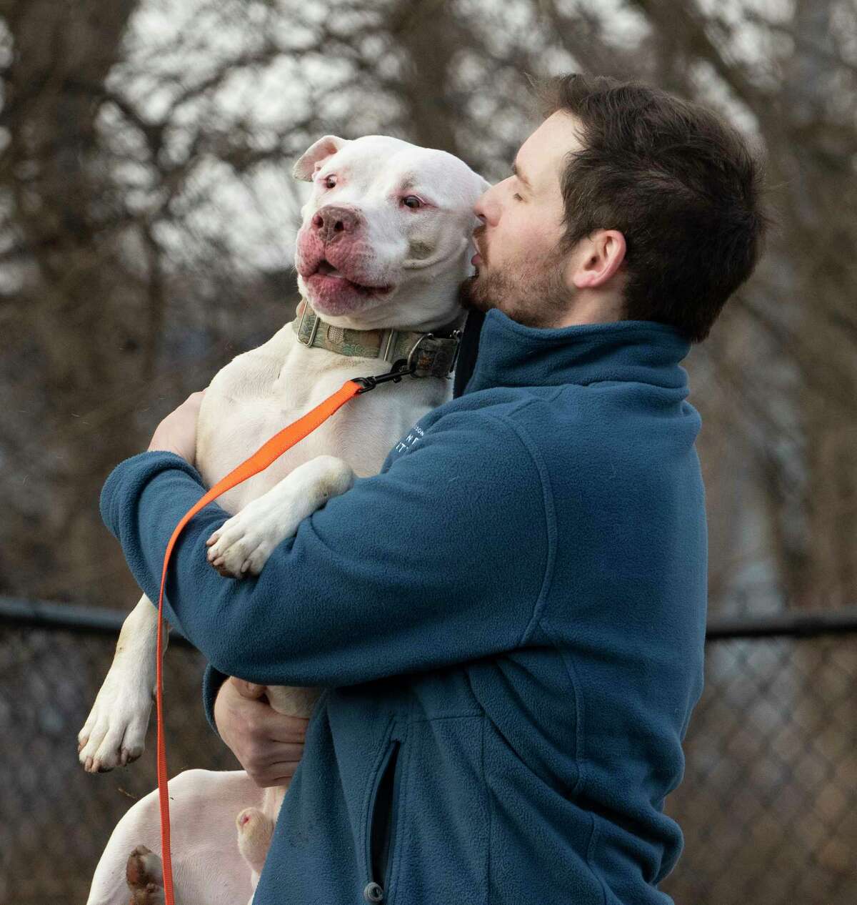 Shelter employee Michael Lansing Jr. picks up and gives mixed breed dog Vail a kiss as he gives him some outside time at the Mohawk Hudson Humane Society on Thursday, Jan. 6, 2022 in Menands, N.Y.