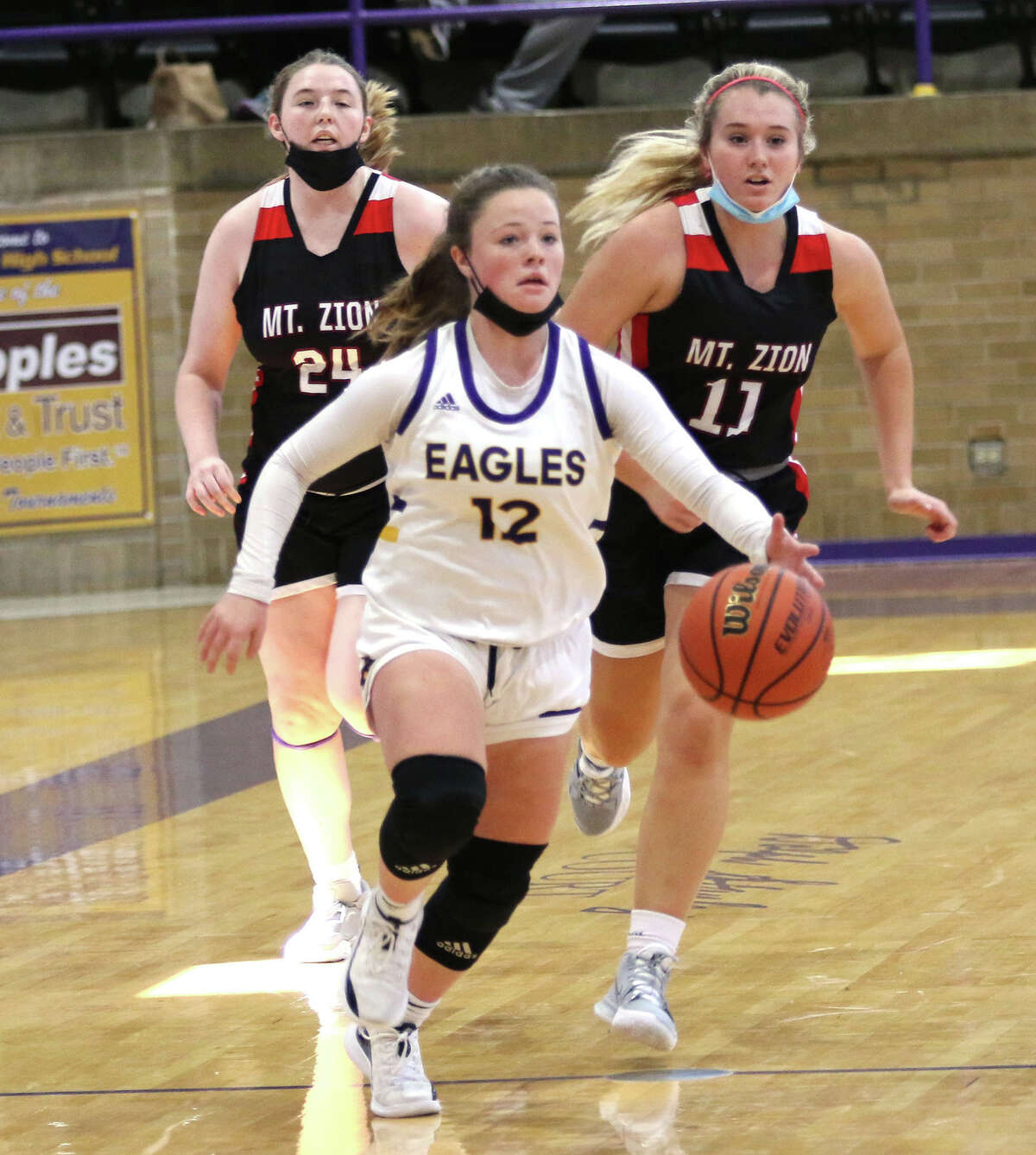 CM's Aubree Wallace (12) pushes the ball upcourt as to Mount Zion Braves give chase in a November game at the Taylorville Tournament. Wallace scored a career-high 30 points Thursday in the Eagles' MVC victory at Mascoutah.