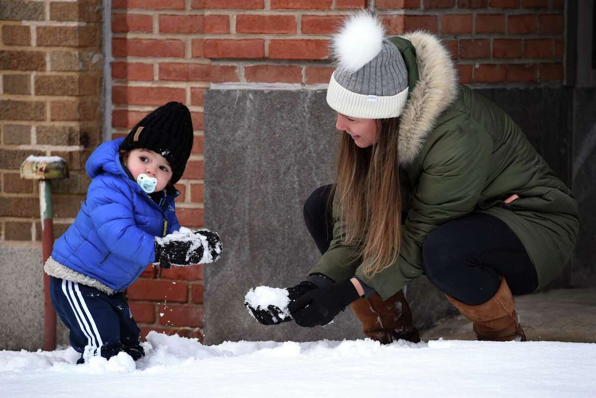 Cal DeFina, 19 months, plays in the snow with his mother, Joanna, on Greenwich Avenue in Greenwich on January 7, 2022.
