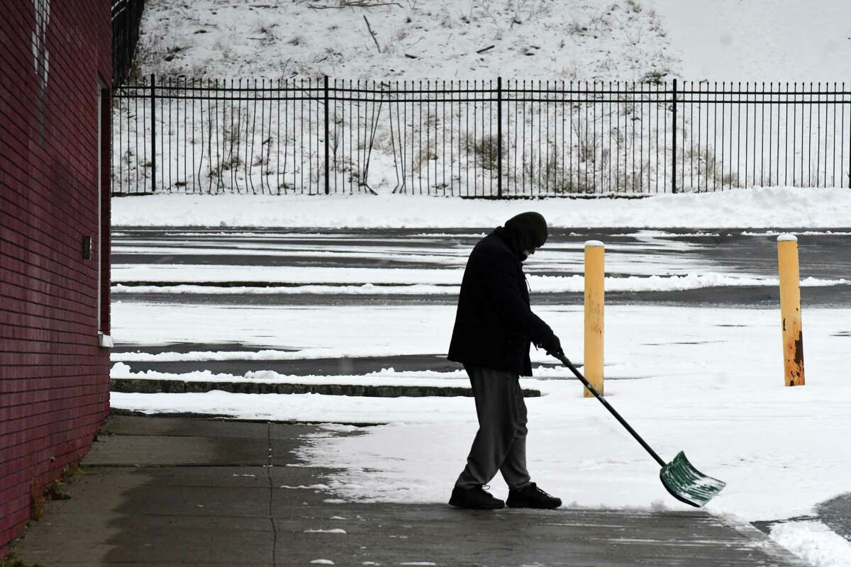 Warm clothes and a snow shovel will come in handy this weekend: The temperature will drop into the single digits by Saturday and snow will move in Sunday night. In this photograph, snow is cleared from the sidewalk outside Uncle Sam Lanes on Jan. 7, 2022, on Fulton Street in Troy.