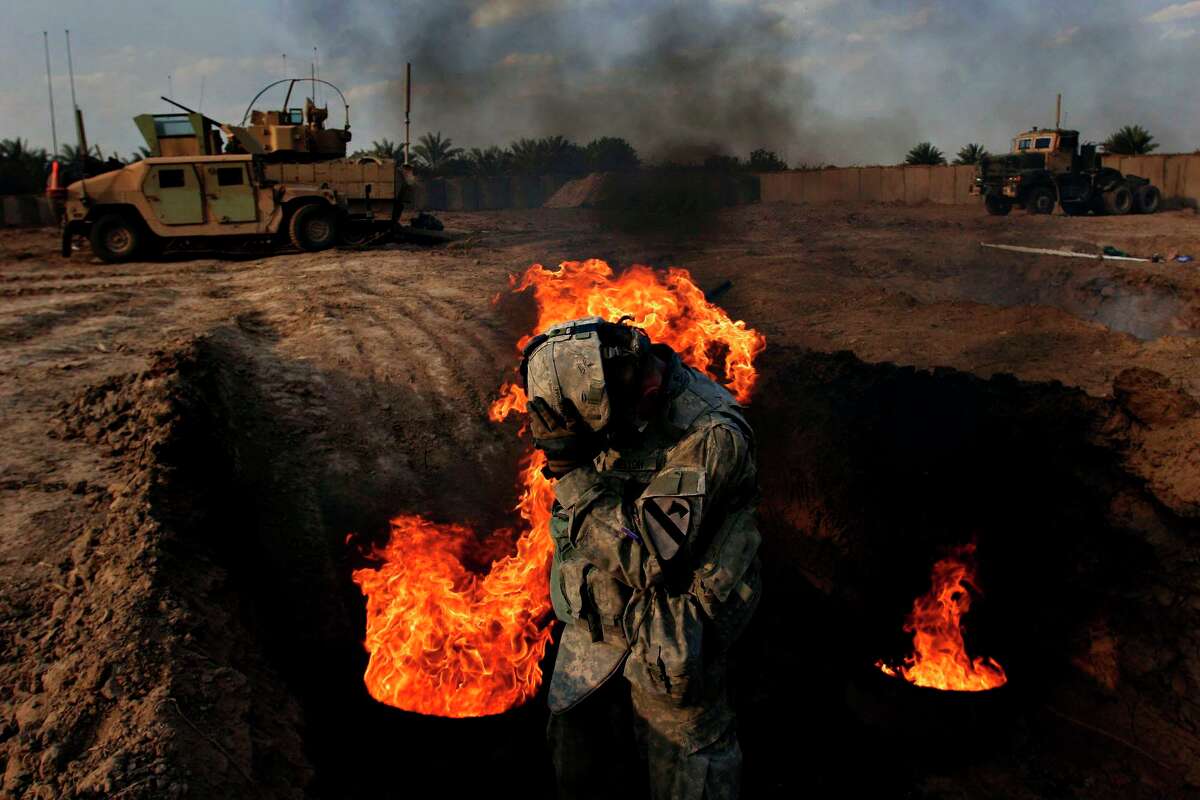 Spc. Phillip Melton of Turon, Kansas burns human waste in the pit at Patrol Base K-wal in Shakarat, Iraq, Monday, March 19, 2007. The detail may be the worst job in the army. Soldiers rotate the duty. "I don't mind. I like fire," Melton said. 