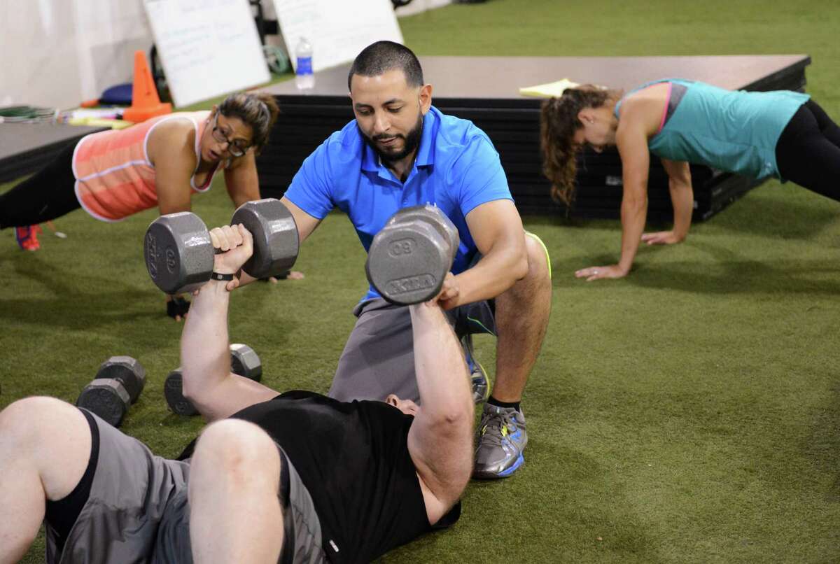 Trainer Christian Oropeza helps members with a workout at Elite Human Performance in Danbury, Conn. on Wednesday, July 10, 2013. Club owner, Christian Oropeza recently traveled to the Phillipines to teach fitness classes.