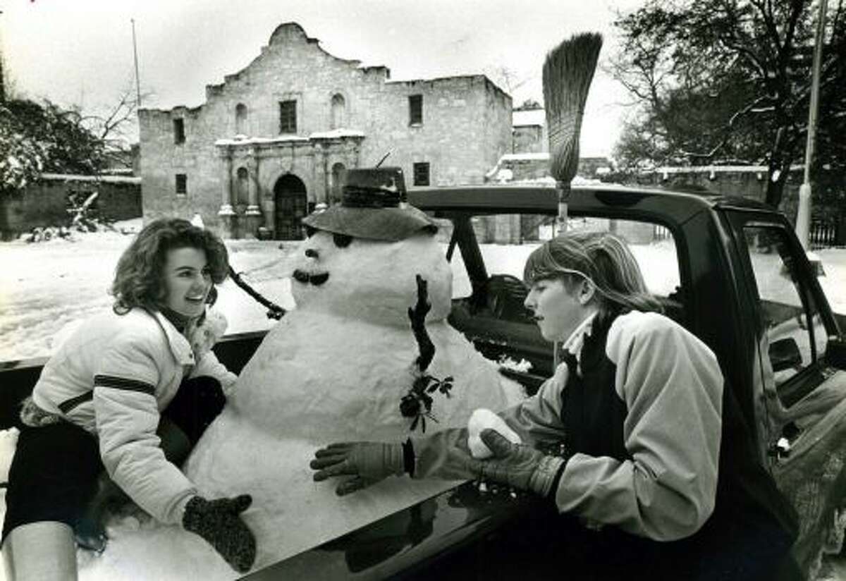 Lolly Flowers, 20, (left) and Leslie Roberts enjoy the snow at the Alamo after building a snowman in the back of a pickup truck belonging to Flowers' brother. This photo, taken nearly a decade before the short street by the Alamo church was closed to traffic, was one of the iconic images from San Antonio's record snowstorm in 1985.
