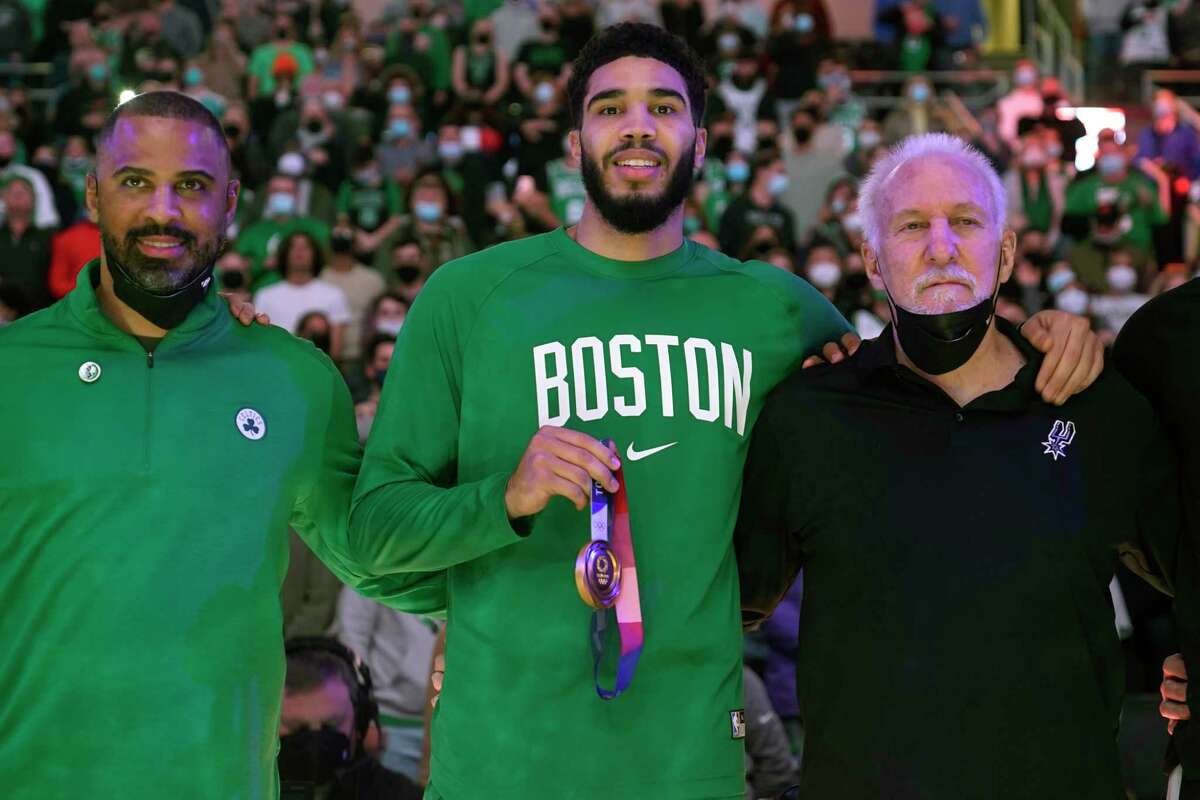 Boston Celtics forward Jayson Tatum, center, poses with San Antonio Spurs and Team USA head coach Gregg Popovich, right, and Boston Celtics head coach Ime Udoka, left, after receiving his USA team gold medal prior to the first half of an NBA basketball game, Wednesday, Jan. 5, 2022, in Boston. (AP Photo/Charles Krupa)