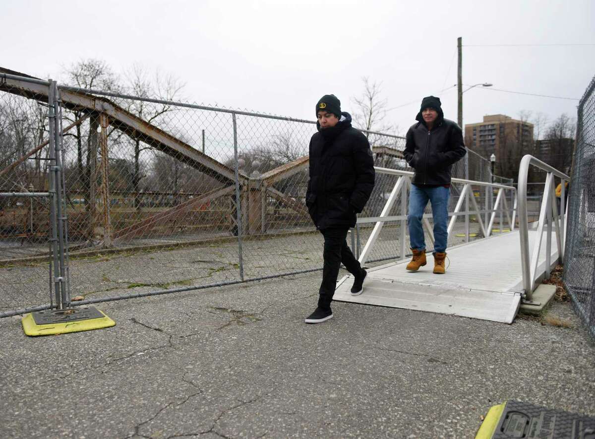 Stamford's Marlo Davila, left, and his father, Otto Davila walk across the West Main Street Bridge in Stamford on Jan. 3.
