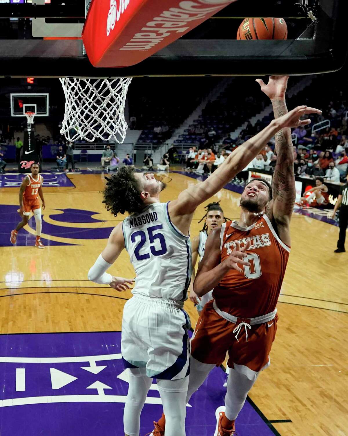 Texas forward Timmy Allen (0) gets past Kansas State forward Ismael Massoud (25) to put up a shot during the first half of an NCAA college basketball game Tuesday, Jan. 4, 2022, in Manhattan, Kan. (AP Photo/Charlie Riedel)