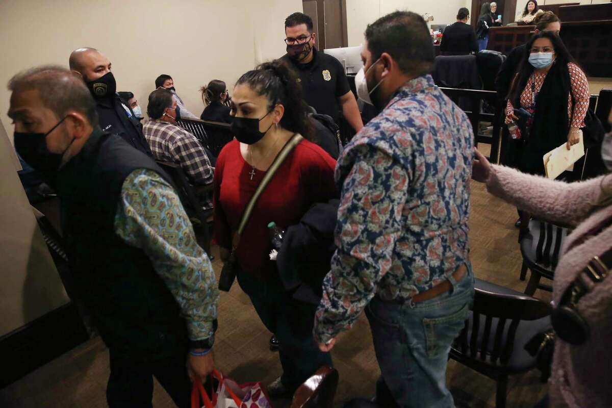 Family of murder victim Kristopher Carraman — including his mother, Michele Carraman, in red — are separated by deputies from the family of his killer, Edison Carraman, as they leave the Bexar County 437th District Court, on Friday, Jan. 7, 2022. Carrraman was convicted in the murder of his cousin in March 2020 and will be sentenced on Monday.