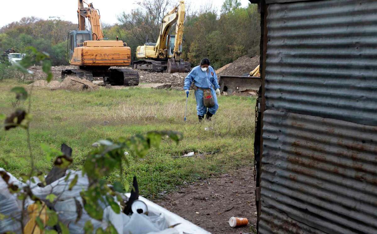 A City of San Antonio worker clears debris left from a homeless encampment off of Austin Highway. The City cleared the camp that has housed up to 20 or more people Friday morning.