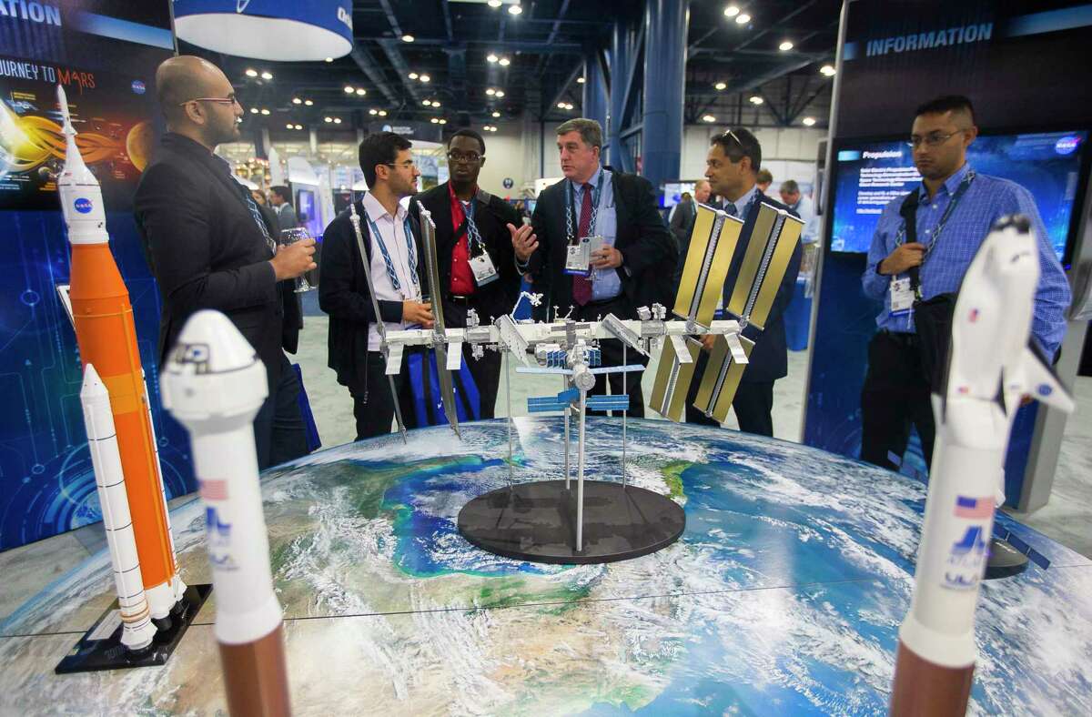 Kirk Shireman (center), who at the time managed NASA's International Space Station program, talks to visitors to NASA's exhibit at SpaceCom during an opening reception at the George R. Brown Convention Center, Tuesday, Dec. 5, 2017, in Houston. ( Mark Mulligan / Houston Chronicle )