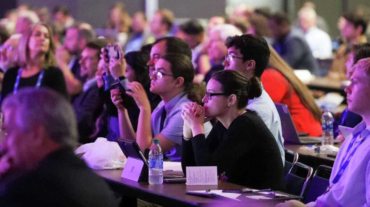 SpaceCom attendees listen and take photos of Bill Nye as he talked during his keynote presentation at SpaceCom Thursday, Nov. 21, 2019, in Houston.
